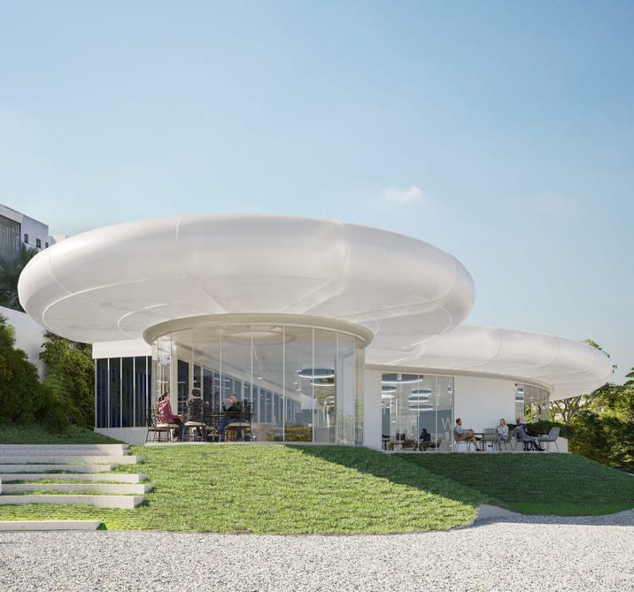 Diseño arquitectónico moderno de un edificio circular y bajo, con grandes ventanales y un entorno verde.